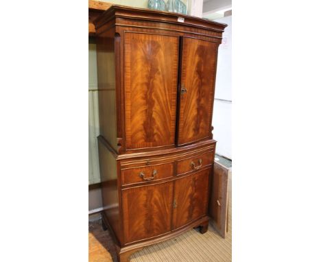 A cocktail cabinet disguised as a reproduction Georgian mahogany cabinet with drawers &amp; cupboards below, on bracket fee, 