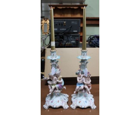 A pair of 20th century Meissen ceramic candlesticks, applied to the stems with children representing the seasons, on Rococo g