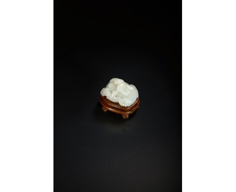 A CHINESE PALE CELADON JADE CARVING OF A BAT QING DYNASTY Crouching upon two large peaches, which issue from a gnarled flower
