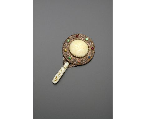 A CHINESE JADE-MOUNTED HAND MIRROR QING DYNASTY The handle formed from a belthook carved with dragons, the mirror-back set wi