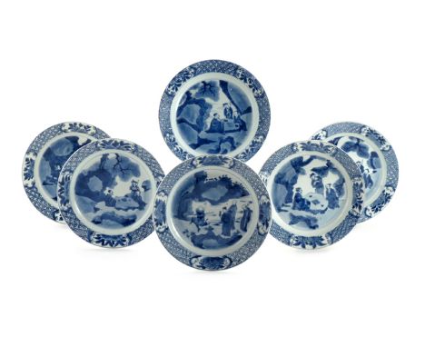 SIX CHINESE BLUE AND WHITE PLATES KANGXI 1662-1722 Painted with figures seated around a rock in a landscape, the borders with