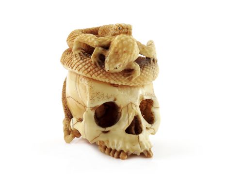 λ A JAPANESE IVORY OKIMONO MEIJI 1868-1912 Carved as a snake coiled around a skull, attacking a toad before him while another