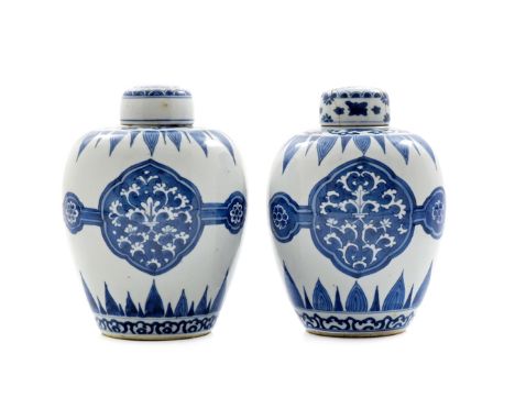 A PAIR OF CHINESE BLUE AND WHITE OVOID VASES AND COVERS KANGXI 1662-1722 Each with three panels painted with leaf scrolls, jo