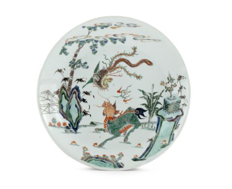 A LARGE CHINESE FAMILLE VERTE DISH KANGXI 1662-1722 Painted with a phoenix in flight above a kylin in a fenced rocky garden, 
