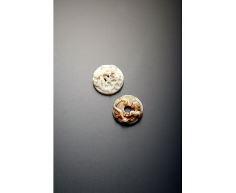 TWO CHINESE CELADON JADE BI DISCS MING DYNASTY Each carved in relief with a sinuous chilong to one side, one with C-scrolls t