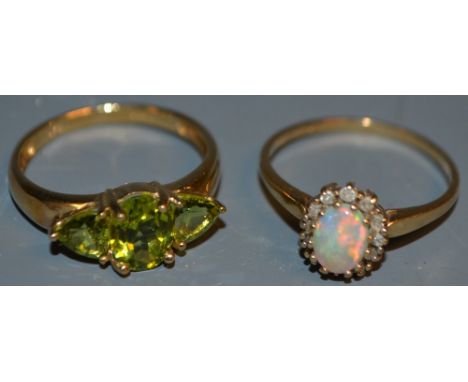 A 9ct gold and opal ring; another 9ct gold ring set with green stones (2)