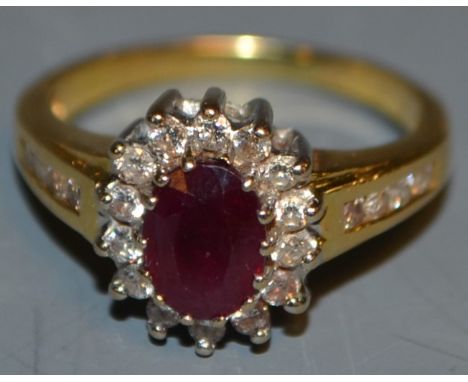 An 18ct gold ruby and diamond cluster, diamond set shoulders