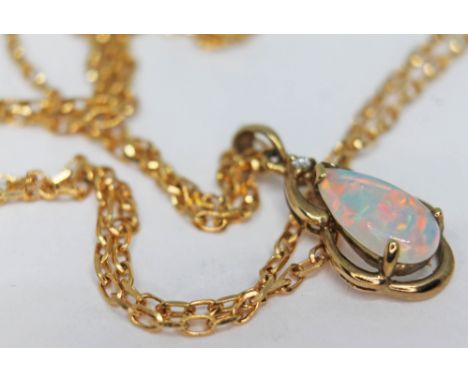 A 9ct gold pendant set with a pear shaped opal cabochon and a diamond, length 22mm, on 9ct gold chain, length 46cm, gross wt.