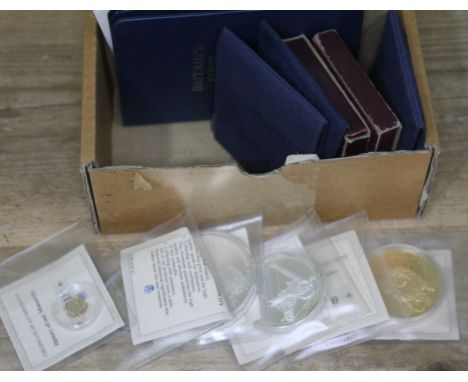 A collection of proof coins including two sets of Britains first decimal coins, commemorative crowns, a 14ct gold History of 