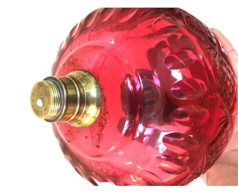 A Victorian cast metal and twist brass column oil lamp with cranberry glass reservoir, height 53cm.Condition: no signs of any