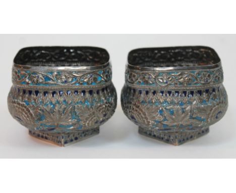 A pair of eastern silver and enamel sugar bowls decorated with flowers, unmarked, height 8.5cm, gross wt. 12oz.  Condition - 