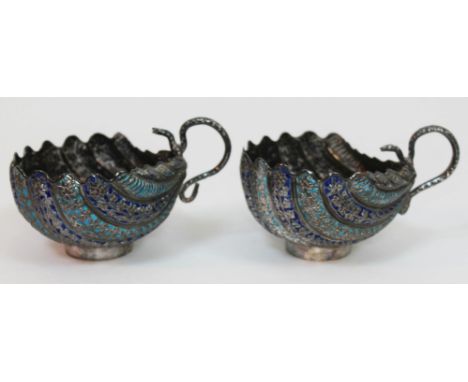 A pair of eastern silver and enamel cream jugs of half clam shell form with serpent handles, unmarked, length 11cm, gross wt.