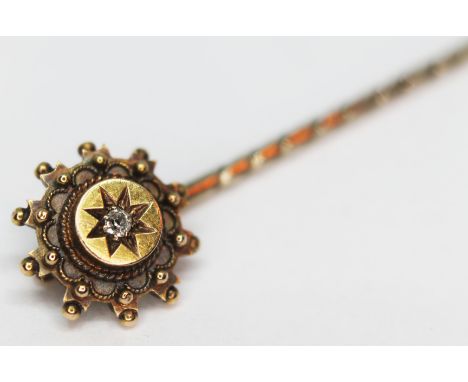 A 15ct gold stick pin set with a diamond, gross wt. 1.67g.  