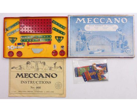 Meccano outfit 000, comprising green and red components, with instructions and guarantee, restrung to the original card base,