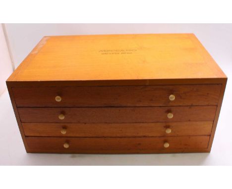 Meccano outfit no.10, housed in a four-drawer oak cabinet, comprising red and green components, mostly unstrung from the card