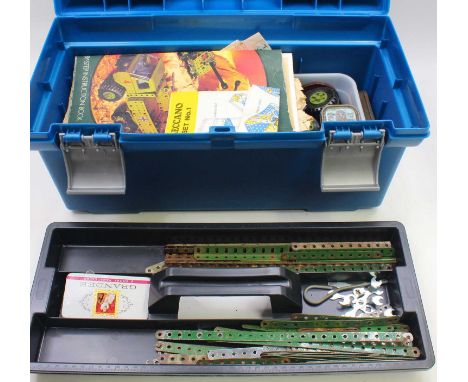 One toolbox containing various Meccano 1960s red and green components, including various gear wheels, wheels, instructions, a