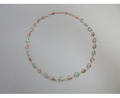 A pastel pink and blue necklace of aquamarines and tourmalines, the graduated line of oval cut light aquamarines alternating 