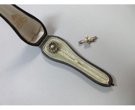 A diamond and pearl flowerhead stick pin together with a cultured pearl and diamond stock pin, the first designed as a many-p