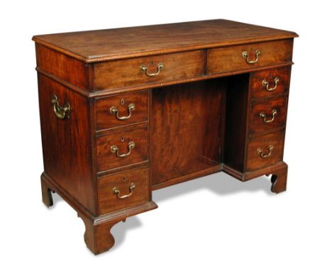An early George III mahogany kneehole library table, having eight drawers, brass side handles, on shaped bracket feet 89 x 12