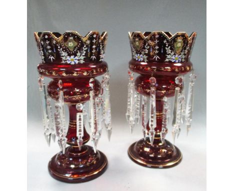 A pair of Victorian ruby glass lustres, each gilded, painted and hung with prismatic drops, under glass domes, 35cm (14in) hi