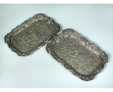 A Victorian composed pair of silver shaped rectangular dressing table trays, Birmingham 1896 and Chester 1900, the fields ext