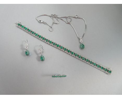 A matched suite of emerald and diamond jewellery, the bracelet composed of pierced links each with an oval cut emerald betwee