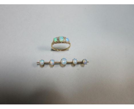 An opal and diamond ring together with an opal bar brooch, the ring with three graduated oval cabochon opals spaced by pairs 