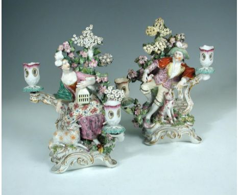A pair of 18th century Derby porcelain figural two branch candlesticks, circa 1770, emblematic of Liberty and Matrimony, both