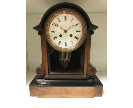 A French late 19th century walnut and ebonised mantel clock, the arched top above 11.5cm white dial, a glass panel below, bel