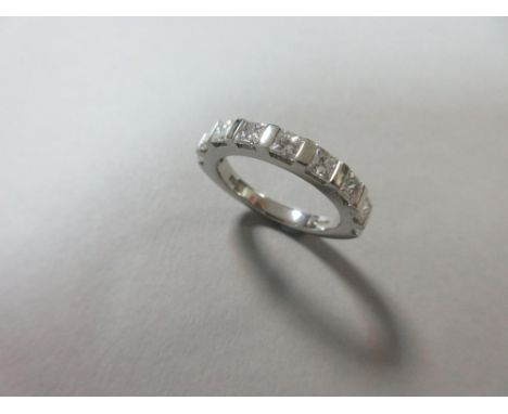 A princess cut diamond and platinum half hoop eternity ring, the nine uniform square cut diamonds tension set between polishe