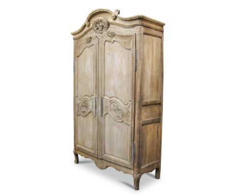 An 18th century French stripped oak armoire, with 'love-bird' carved cresting, long panel doors on scroll feet 230 x 143 x 56