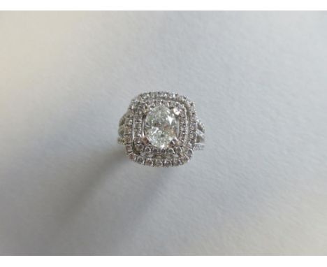An oval cut diamond ring in a double surround of round brilliants, the oval brilliant cut diamond, estimated weight 1.00cts, 