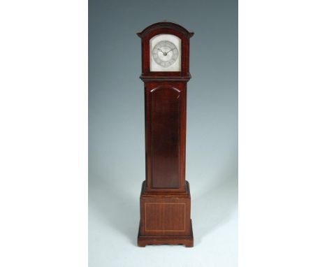 A miniature mahogany longcase clock, retailed by Finnigans, the break arch case with machine turned silvered 6cm dial, recess