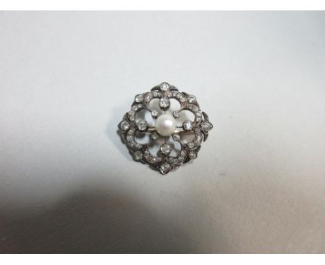 An Edwardian diamond and pearl brooch, the central 5.7mm pearl in a pierced surround of four double petals, set throughout wi