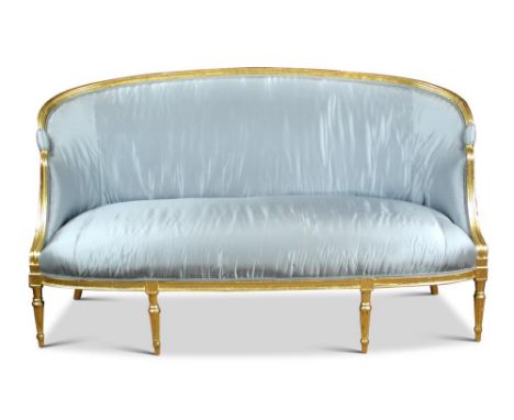 An 18th century gilt framed sofa, with a curved back, upholstered in a pale blue fabric, with arm rests and on fluted taperin