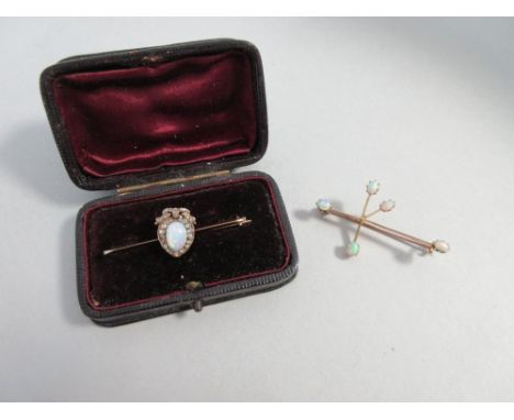 An antique opal and diamond brooch and a modern Australian opal brooch, the first a knife-edge bar brooch set to the centre w