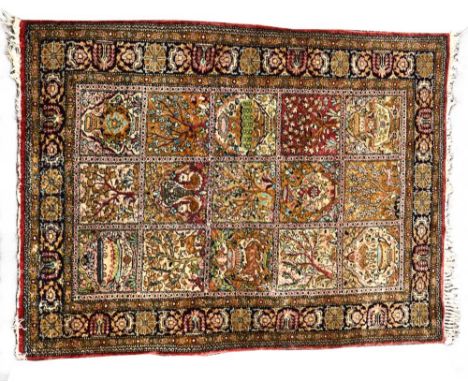 A small silk rug, of Bakhtiari design, decorated with urns and plants to the central field of fifteen reserves 117 x 81cm (46