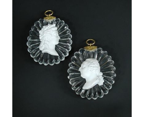 A pair of 1820s Baccarat sulphide plaques of Louis XVI and Marie Antoinette, the clear glass ovals with star moulding on the 