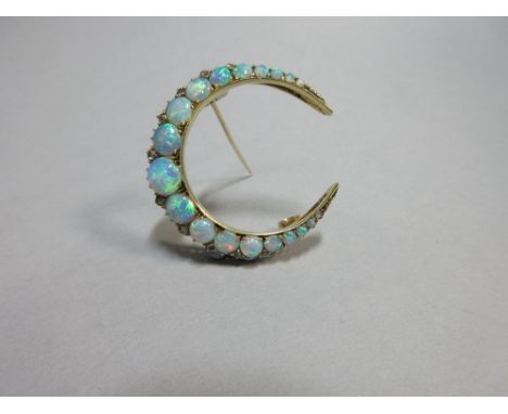 An opal and diamond crescent brooch, the closed crescent set with a graduated line of round cabochon opals of fine and varied