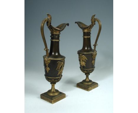 A pair of French Empire gilt and patinated bronze ewers, each ewer with a handle cast as the head of a rooster, the bodies ap