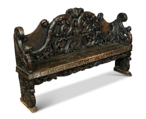 An 18th century Dutch Renaissance carved oak hall bench, boldly carved back with large scrolls, leaf and palmette designs, co