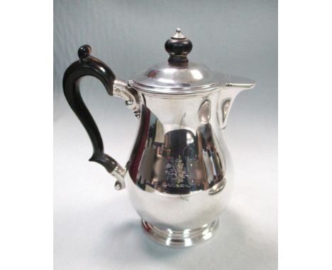 A William IV silver hot water jug, by R & S Garrard & Co, London 1832, the baluster body engraved with a family crest, the sl