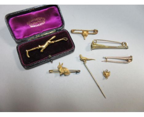 A collection of hunting stock pins and other pieces, the first a running fox on a hunting crop, in a period fitted leather ca