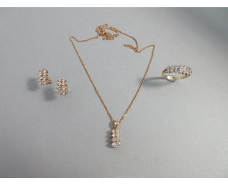 A diamond and 18ct gold suite of pendant, earstuds and ring, each piece set with graduated twin lines of round brilliant cut 