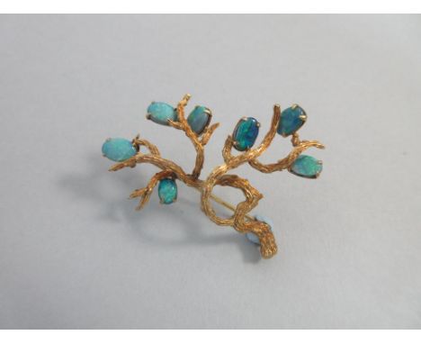 A black opal doublet brooch in the form of a tree, the realistically modelled and textured branch or tree set with seven frui