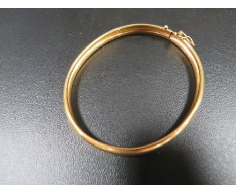 A yellow metal clasp bangle marked 916 approx. weight 12.9g
