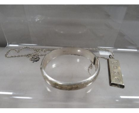A hallmarked silver ingot on chain together with a hallmarked silver bangle