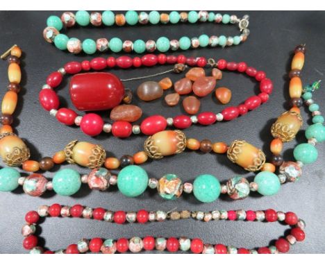 A selection of vintage bead necklaces to include a cherry amber style dropper