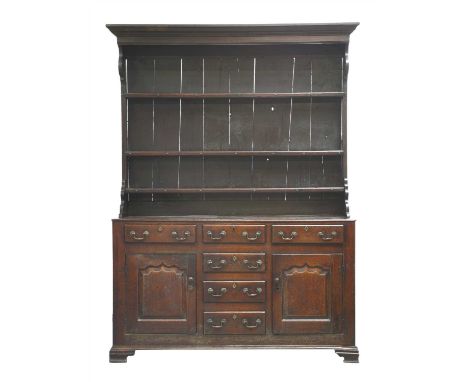 A George III oak dresser, the closed plate rack over a base with three frieze drawers and three central drawers, flanked by p
