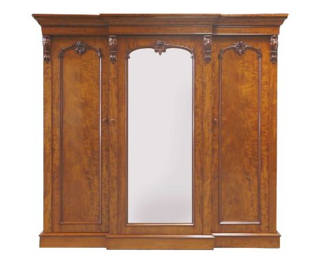 A Victorian mahogany breakfront wardrobe, with a centre mirror door, flanked by cupboard doors, on a plinth base, 226cm wide 